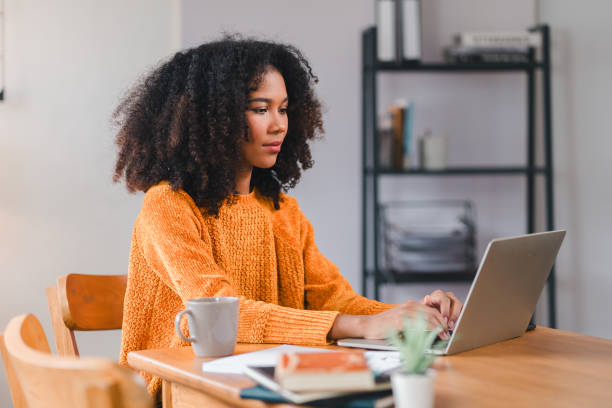 istock Smiling African American woman using a laptop while working from home. 2167006054