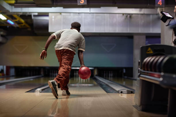 Enjoying Evening Bowling Game Holding Shining Red Ball