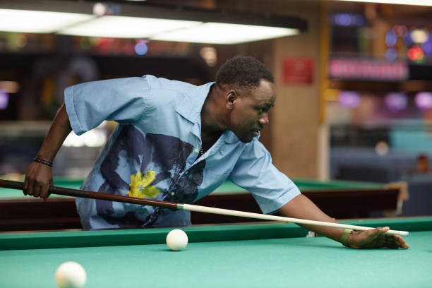 istock Playing Billiards in Dimly Lit Recreational Area 2167006564
