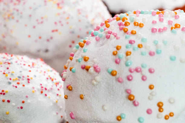 This is a photo of cupcakes with pink icing and white sprinkles on top. The focus is on the cupcake in the middle.