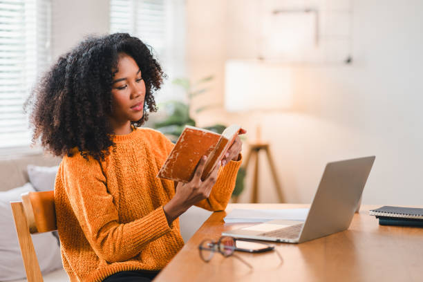 istock Smiling African American woman reading a notebook while working at home. 2167007060