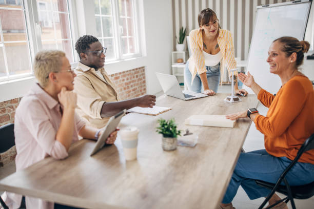 istock Colleagues at a meeting table with whiteboard discussion 2167007784