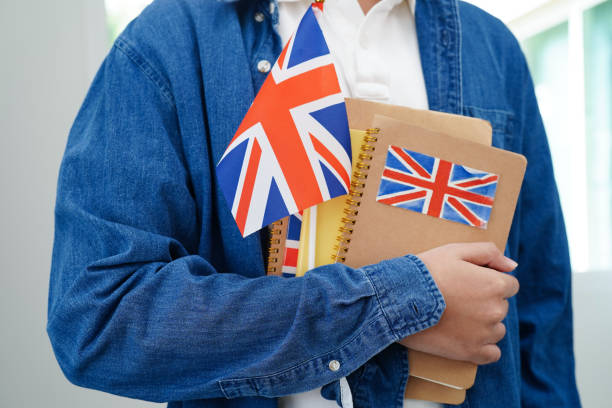 istock Learning English, Asian teenage student holding book with flag for language program education. 2167008566