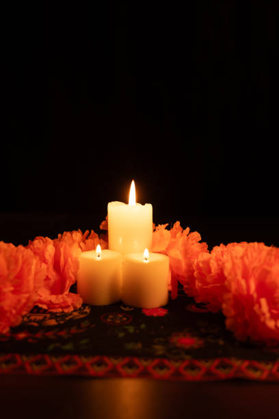 istock A vertical view showing three glowing candles surrounded by bright orange marigold flowers 2167009512