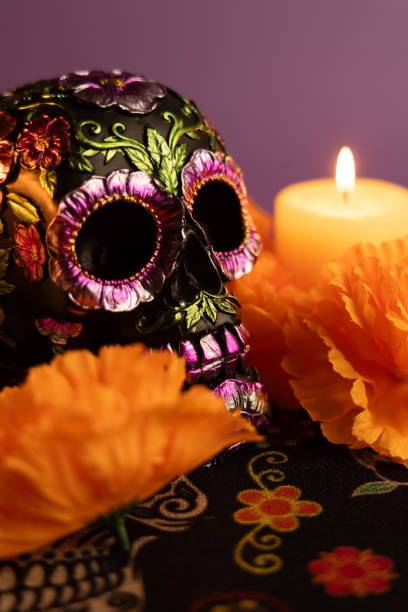 istock A vertical composition featuring a skull decorated with metallic flowers, framed by one lit candle 2167009577