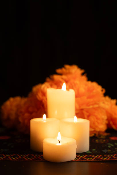 istock Three flickering candles are centrally placed, surrounded by vivid orange marigold blooms 2167010181