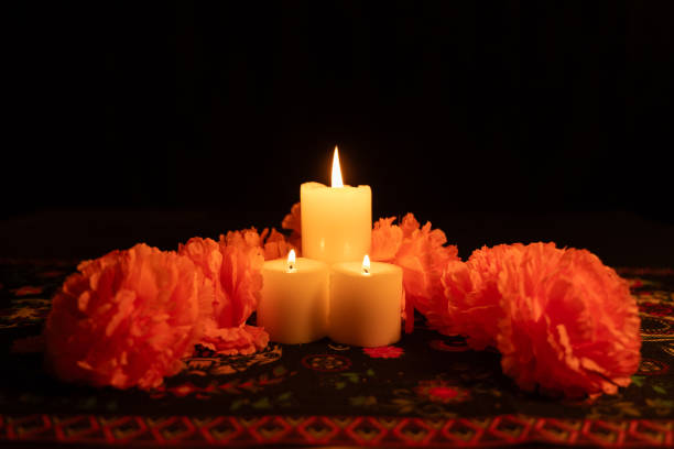 istock Three candles shine brightly in a vertical shot, encircled by orange marigolds 2167010357