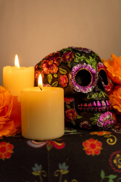 istock Vertical image showcasing a detailed skull with metallic flower embellishments. Surrounded by vivid orange marigolds and two lit candles 2167010816