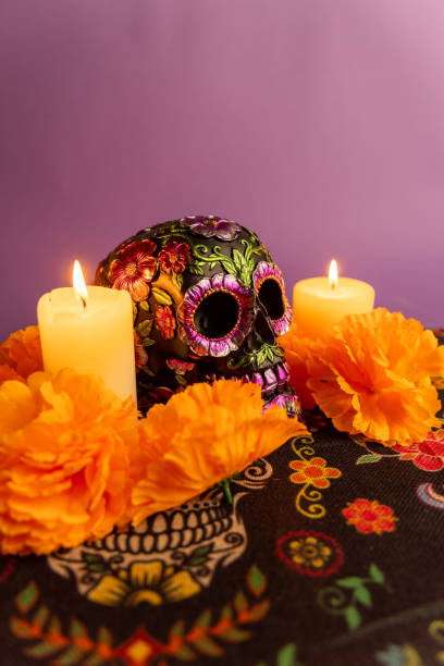 istock A vertical image showcasing a decorated skull with metallic flowers, flanked by two lit candles 2167010920