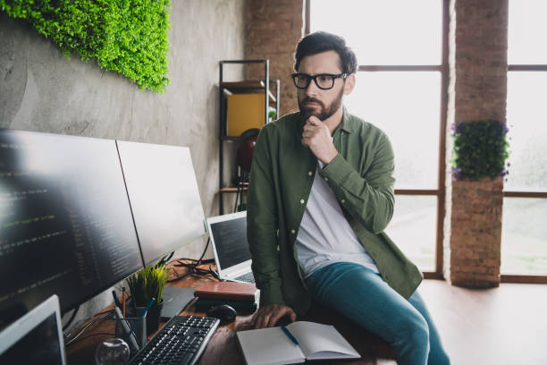 istock Portrait of professional hacker young man think computer desk loft interior office indoors 2167012800