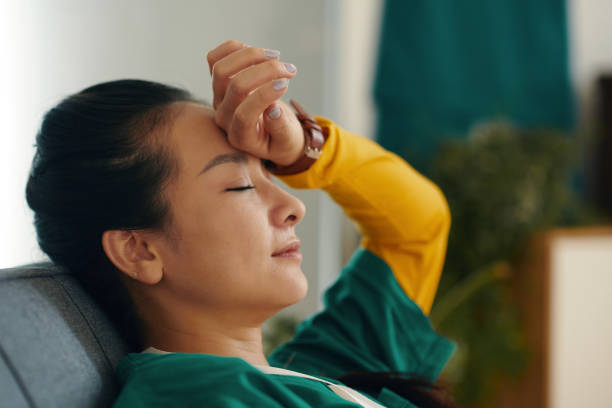 istock Relaxing on Couch Resting Hand on Forehead with Eyes Closed 2167015213