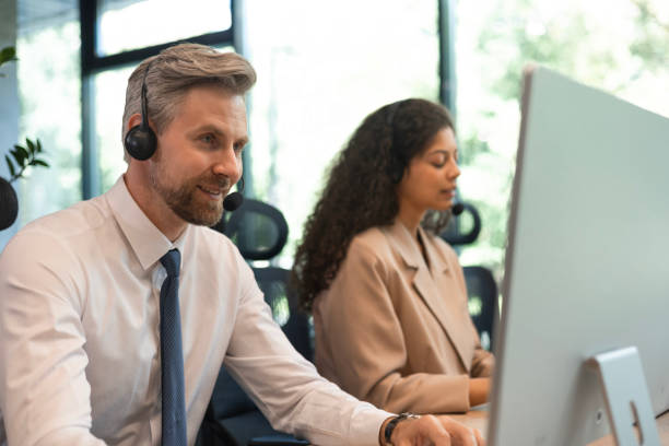 istock Portrait of call center worker accompanied by his team. Smiling customer support operator at work. 2167017130