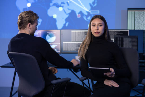 istock Serious Female Cybersecurity Analyst in large Cyber Security Operation Center SOC handling Threats 2167017138