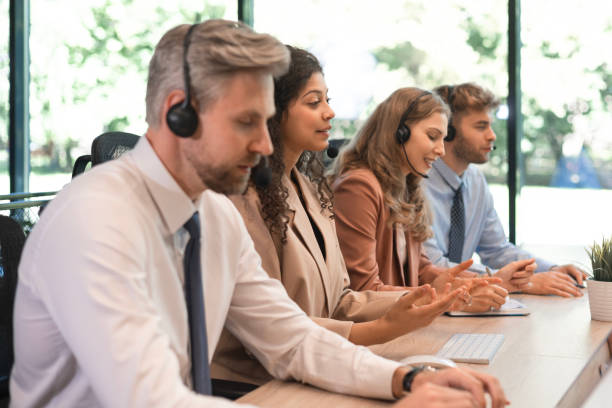istock Portrait of call center worker accompanied by his team. Smiling customer support operator at work. 2167017628
