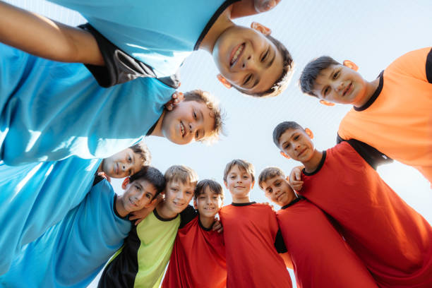 istock Happy Boys in Sports Jerseys Forming a Team Huddle 2167019678