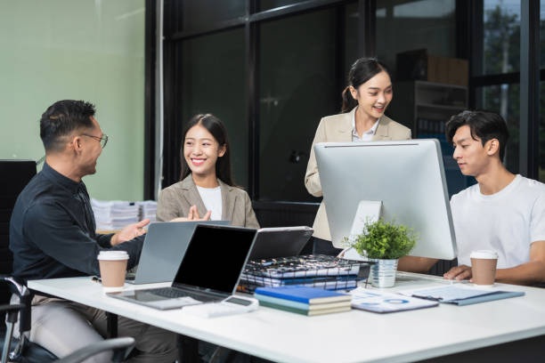 istock Business documents on office table with tablet and laptop computer and chart and two colleagues discussing data in office. 2167020333
