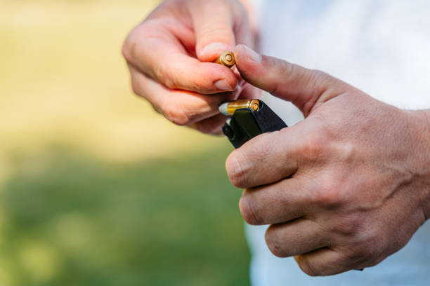 istock Mid-Adult Man Inserting Bullets Into His Handgun And Preparing For Shooting Practice 2167024005