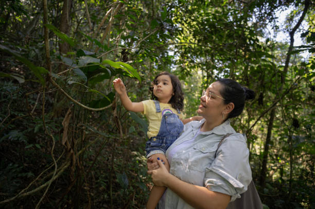 istock Mother teaching her little daughter respect for nature. Huge tree from the Amazon rainforest. 2167024159