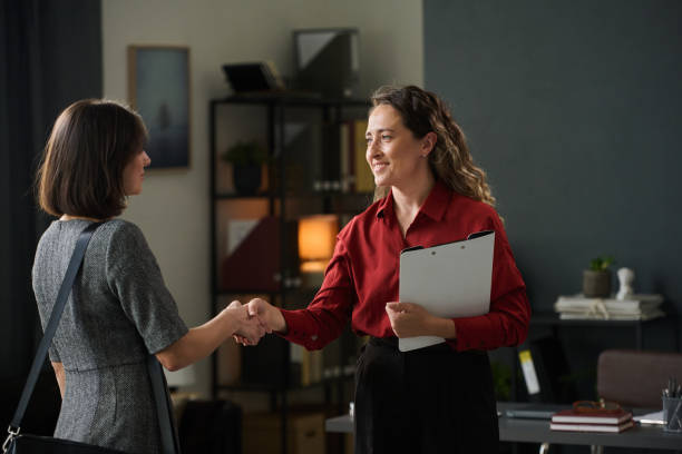 istock Two Businesswomen Shaking Hands in Modern Office 2167024403