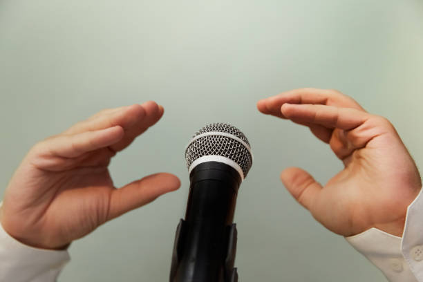 istock Two hands, each seemingly speaking or arguing with the other, in front of a microphone. A debate between political candidates. Public controversy, public debate, fake news, public conflict 2167024989