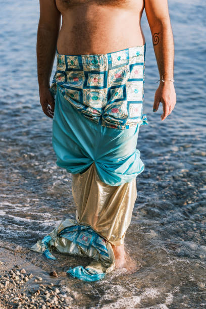 Young man at the beach in sunset. He is dressed in vintage costume. Exterior of lake beach in Muskoka area of Ontario, Canada.