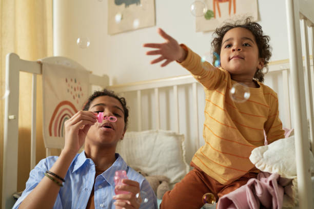 istock Blowing Bubbles in Child's Bedroom with Joyful Expressions 2167026022