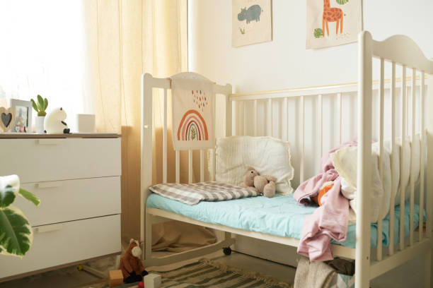 Sunlight illuminates cozy nursery with crib, stuffed animals, and minimalist decor creating warm and inviting atmosphere suitable for child's rest and playtime