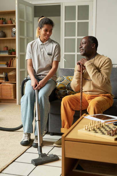 istock Smiling Young Woman Vacuuming Living Room While Talking 2167026054