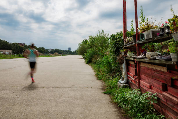 man running beside urban garden in Berlin at Tempelhofer Feld