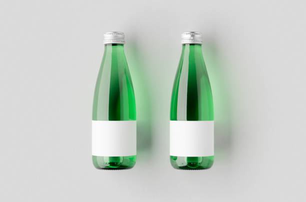 istock Small water bottle mockup with blank label. Green glass. 2167035370