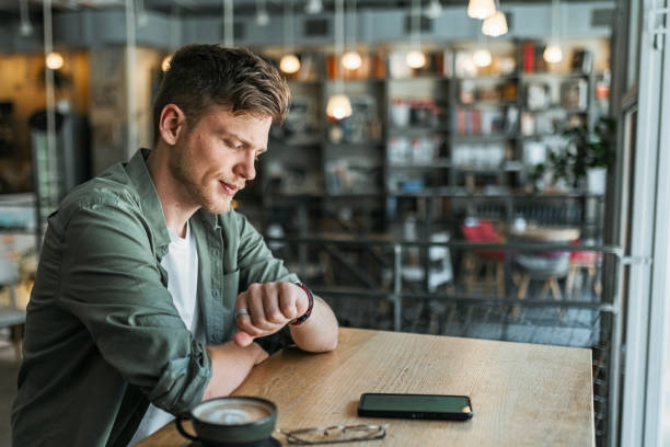 istock Man Looking At Watch In a Trendy Bookstore 2167035449