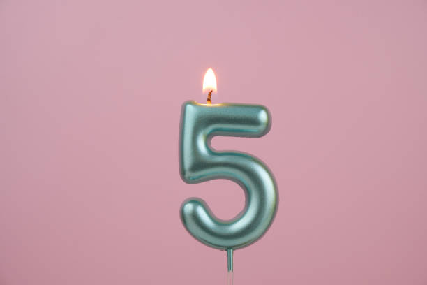 istock Blue birthday candle on pink background, number 5 2167036316