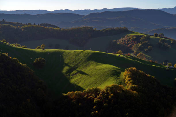 Montefeltro autumnal hilly landscape with woods and fields in oblique light