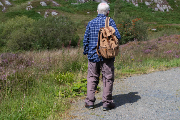 Senior man on a footpath in a remote rural location in Scotland on a summer morning