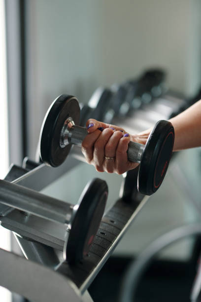 istock Woman Lifting Dumbbells At Training 2167040819
