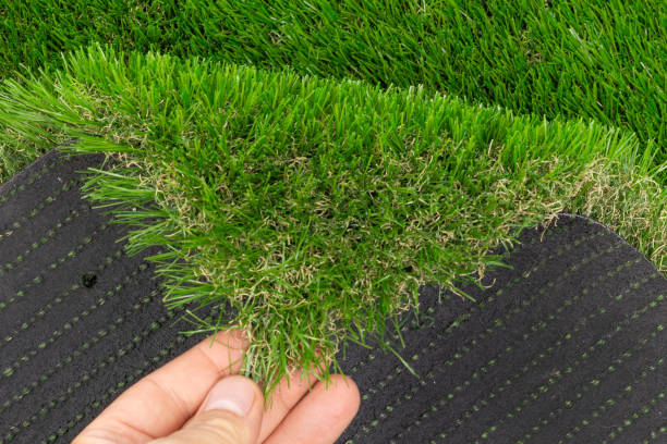 istock Hand Holding Edge of Artificial Grass Roll 2167047491
