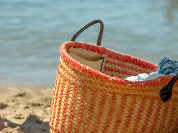 istock Wicker beach bag on the sand. 2167051724