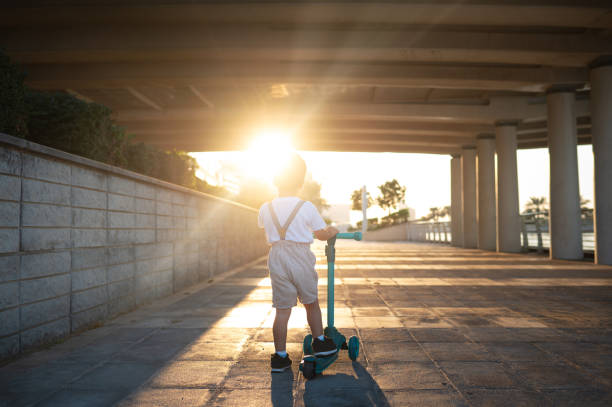 Child on Scooter Enjoying Sunset Under the Highway Bridge Outdoors Activity