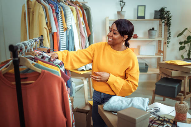 istock Young smiling beautiful woman taking clothes from clothes rack 2167062880