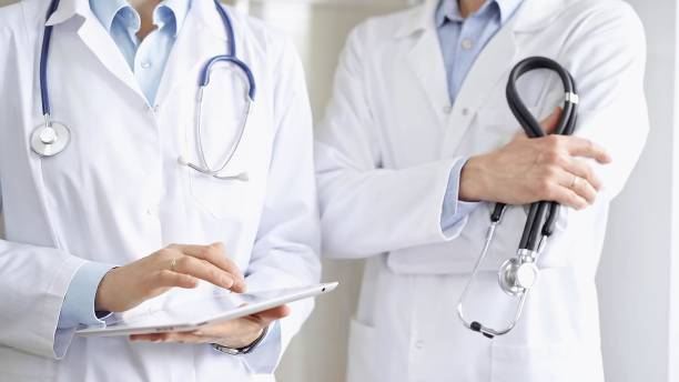 istock Two doctors wearing white coats and stethoscopes, using a digital tablet, discussing a patient's medical history. Medicine and science 2167063185