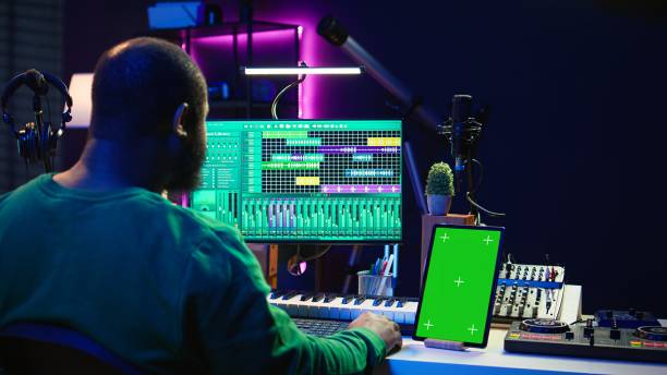 istock Songwriter composer mixing and mastering tracks next to green screen 2167065494