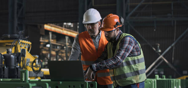 istock Two heavy industry engineers work using laptop and mobile phone at factory 2167065716
