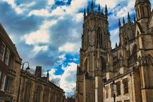 istock Dramatic sky over a majestic Gothic cathedral with intricate architecture, flanked by historic buildings, showcasing a blend of heritage and natural beauty in York, North Yorkshire, England. 2167066861