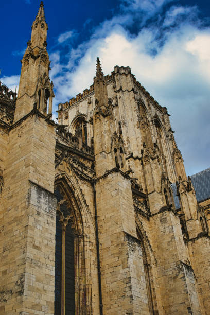 istock Gothic cathedral facade against a blue sky with clouds. The image captures the intricate architecture and towering spires of the historic religious building in York, North Yorkshire, England. 2167066872