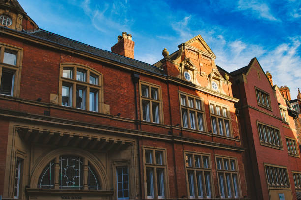 istock Traditional red brick building with ornate windows under a clear blue sky, showcasing classic architectural details and warm sunlight casting shadows in York, North Yorkshire, England. 2167067072