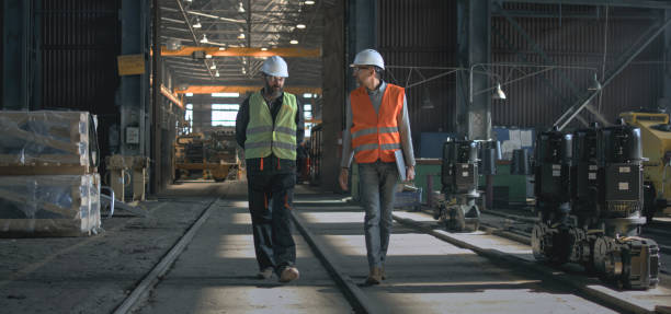 istock Two heavy industry engineers discuss work process walking at factory 2167067380