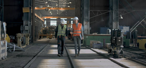 istock Two heavy industry engineers discuss work process walking at factory 2167067757