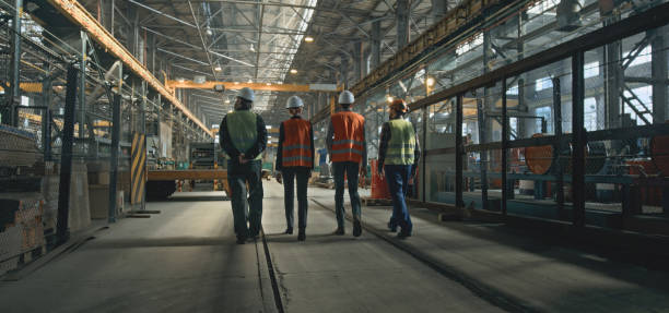 istock Back view of four technicians discussing production, walking at plant 2167067948