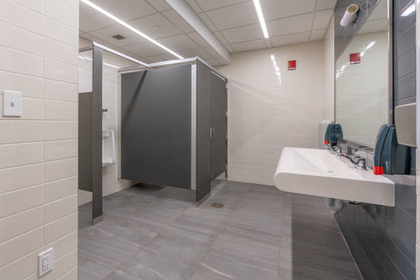 istock Public restroom with gray and white tile stalls, sink and lavatories 2167069551