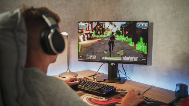 Caucasian teenager plays 3D third person shooter on computer